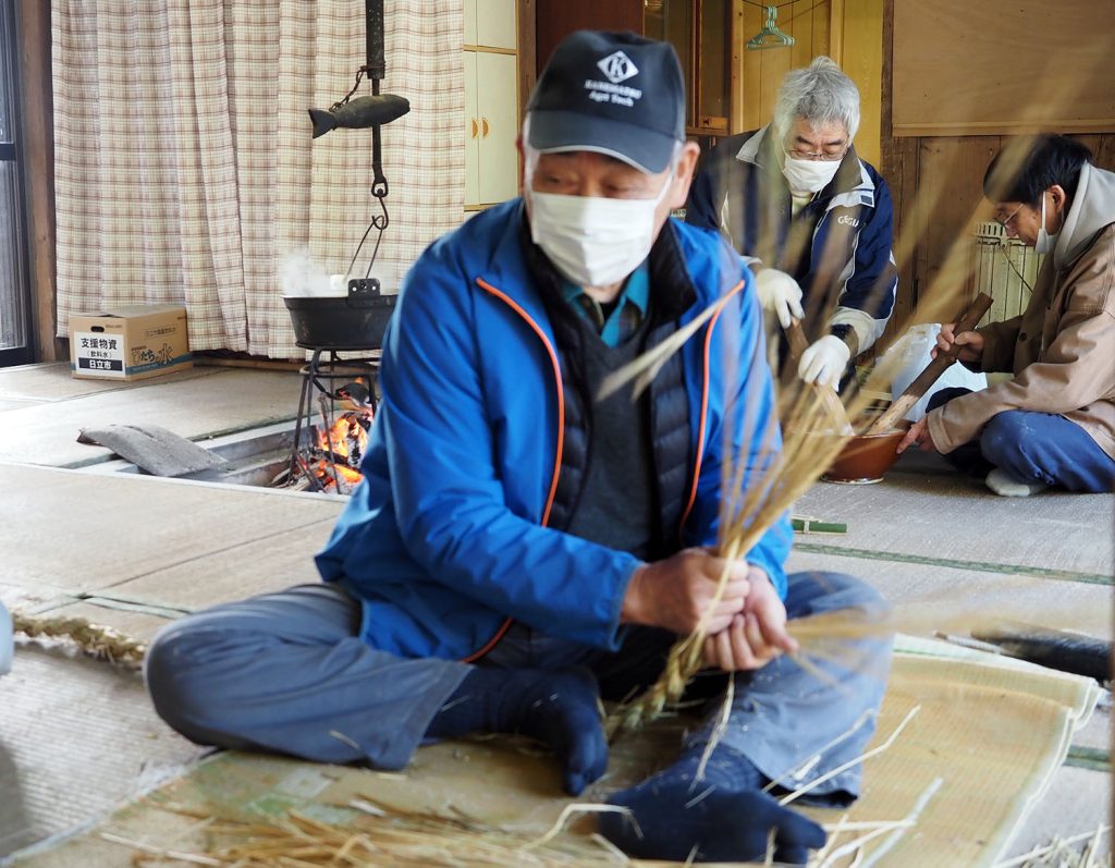 稲わらを編む川名晴作さん（77歳）。