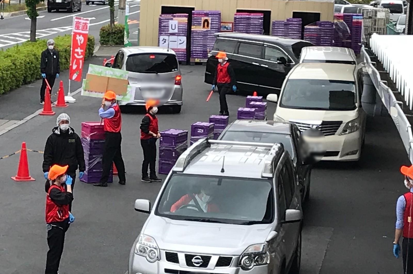 配送センター前にて。購入者たちの車が並ぶ