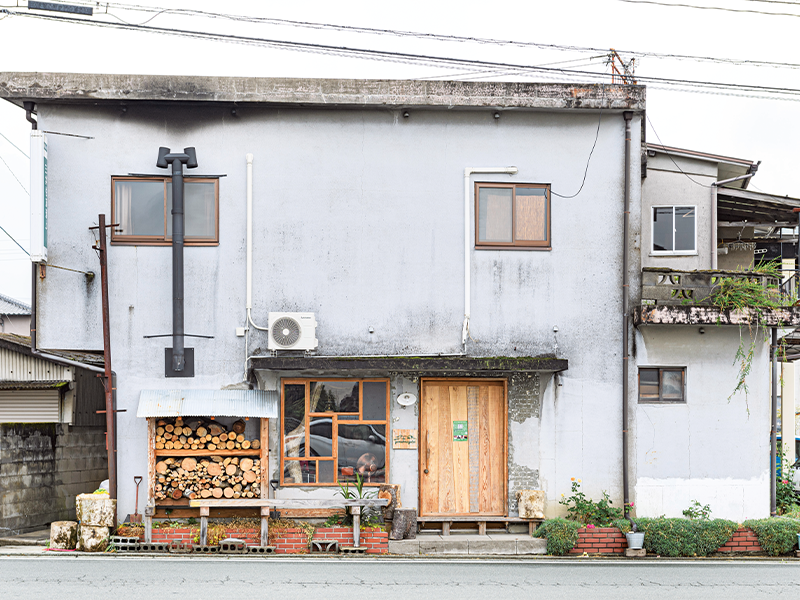 泊まれる山小屋『yamaberinglab』は黒木町の町中にある。入口横に薪が積まれている。