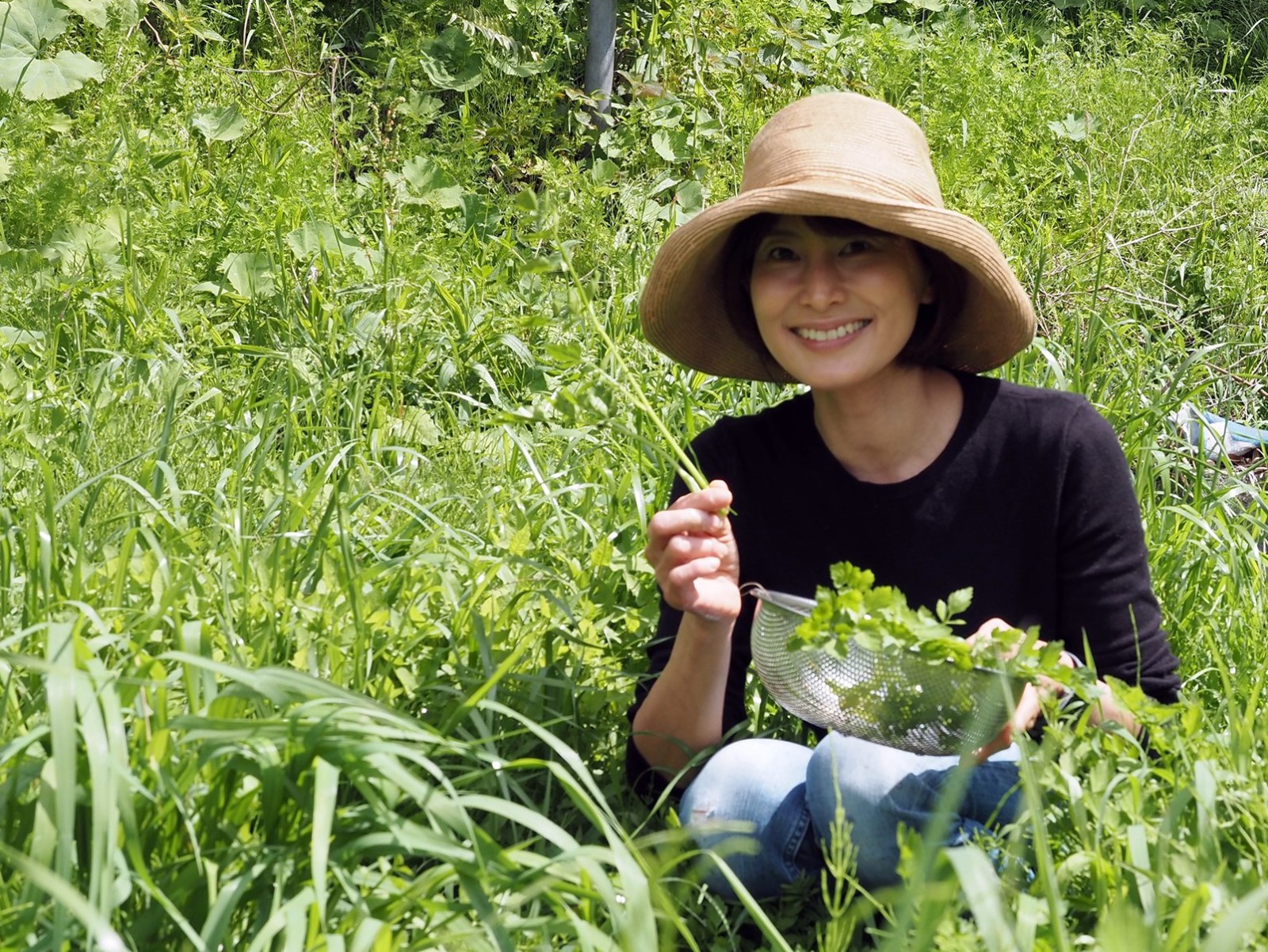 敷地内でセリを収穫する馬場未織さん